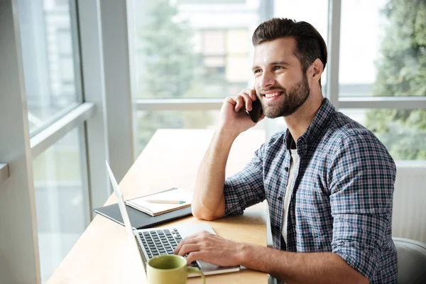 Szczęśliwy człowiek, w biurze coworkingowa, rozmawiając przez telefon. — Zdjęcie stockowe