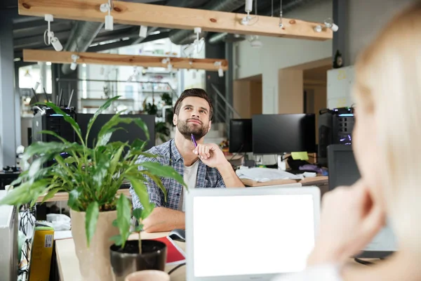 Felices dos colegas en la oficina coworking mientras se utiliza computadoras portátiles — Foto de Stock