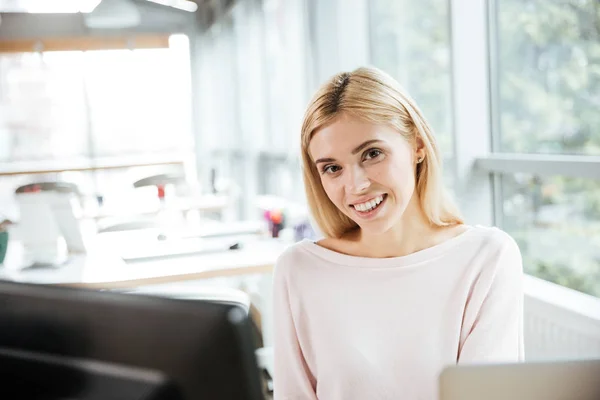 Senhora alegre sentado no escritório coworking usando computador . — Fotografia de Stock