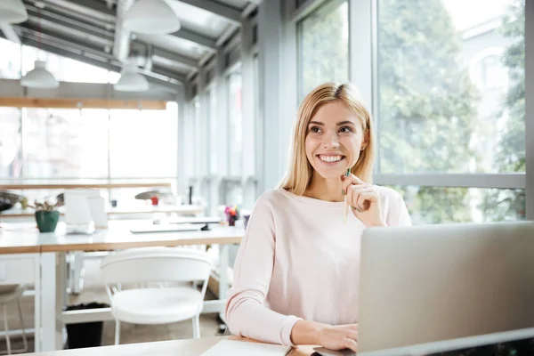 Cheerful lady sitting in office coworking while using laptop — Stock Photo, Image