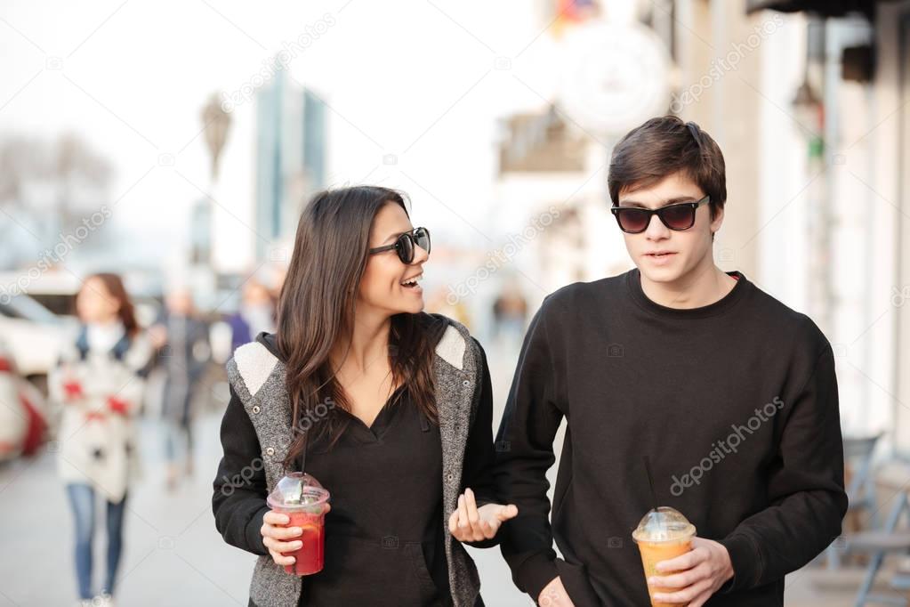 Smiling young lady walking outdoors with her brother