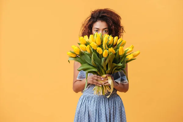 Hübsche afrikanische Frau versteckt sich hinter Blumenstrauß — Stockfoto