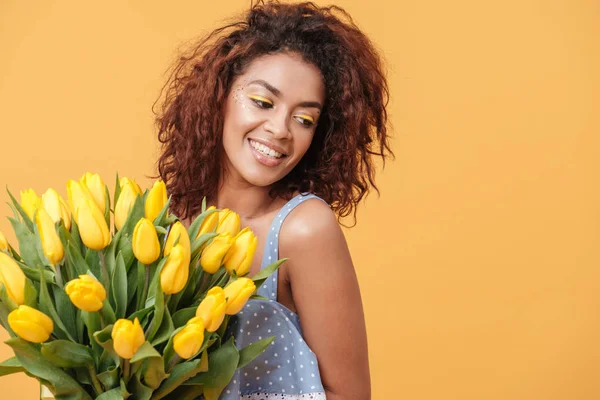 Pleased African woman holding bouquet of flowers — Stock Photo, Image