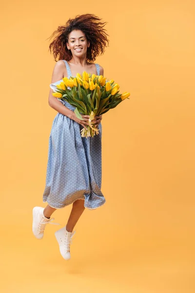 Full-length portrait of  African woman jumping with bouquet  flo — Stock Photo, Image