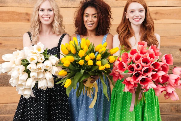 Tre donne felici che tengono mazzi di fiori — Foto Stock