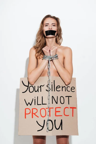 Naked young caucasian woman standing in chain over white wall — Stock Photo, Image