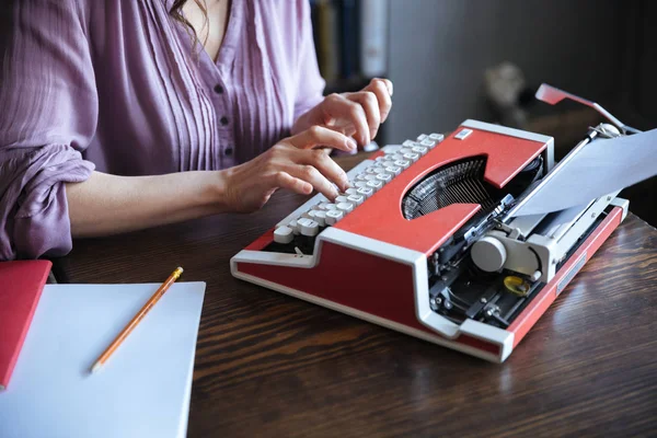 Autorka, sedí u stolu a psaní na typerwriter uvnitř — Stock fotografie