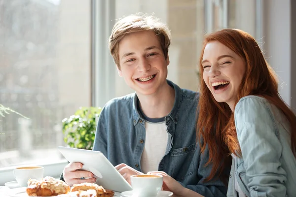 Estudantes rindo sentados no café — Fotografia de Stock