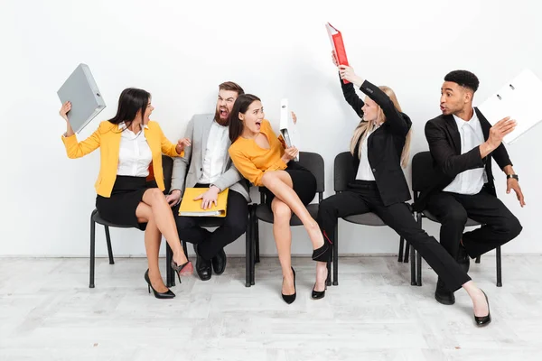 Gritando colegas enojados luchando con carpetas — Foto de Stock