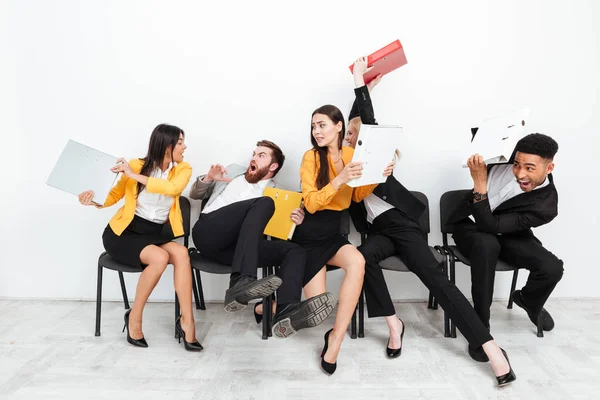 Screaming angry colleagues fighting with folders — Stock Photo, Image