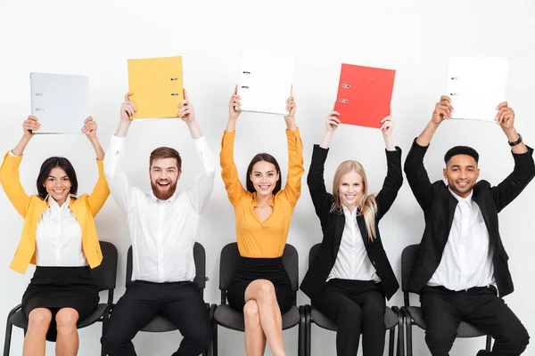 Glada kollegor sitter i office håller mappar. — Stockfoto