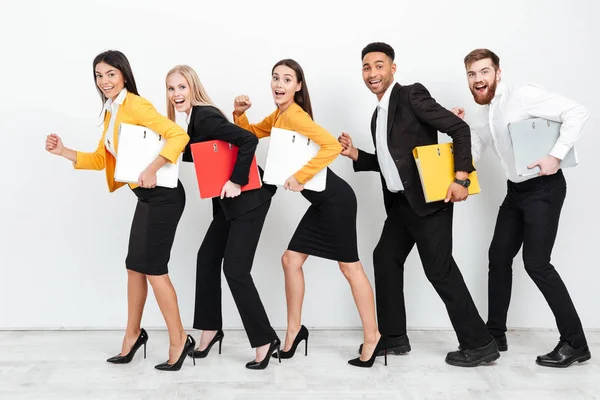 Счастливые коллеги ходят изолированные с папками в офисе — стоковое фото