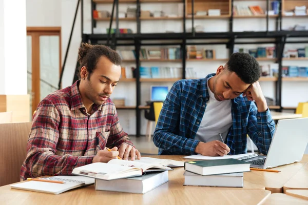 Twee multiculturele mannelijke studenten die studeren met laptop — Stockfoto