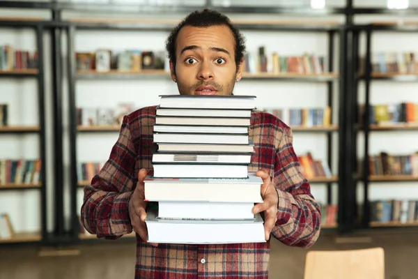 Verwirrter afrikanischer Student steht in Bibliothek — Stockfoto