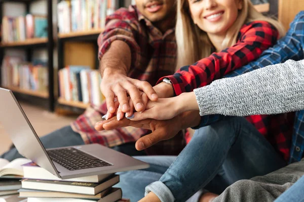 Photo recadrée de jeunes étudiants souriants assis dans la bibliothèque — Photo