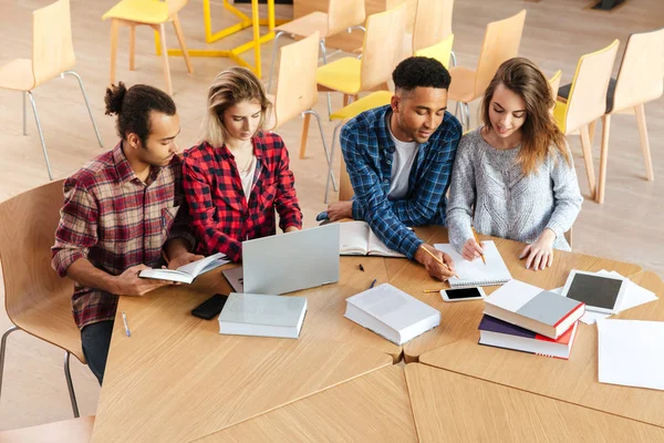 Estudantes sentados na biblioteca — Fotografia de Stock