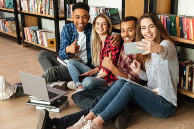 Mutlu öğrenciler Kütüphane katta oturan selfie olun