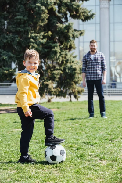 Aranyos fiú apja a parkban focizni — Stock Fotó