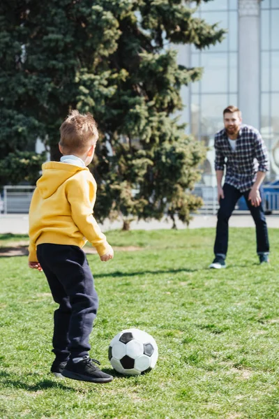 Pequeño niño divirtiéndose jugando fútbol con su padre — Foto de Stock