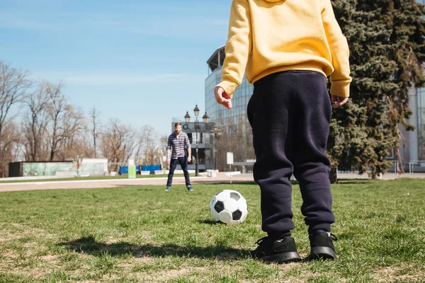 Bearded father playing football with his little son