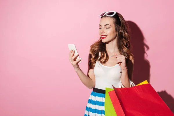 Fröhliche Frau mit Einkaufstüten tippt Nachricht auf Handy — Stockfoto