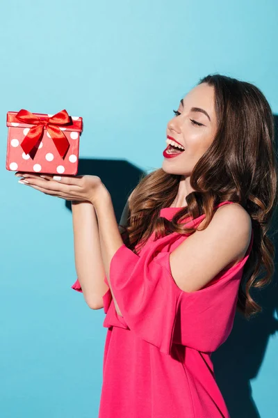 Hübsches Mädchen im Kleid mit Geschenkbox auf ihren Handflächen — Stockfoto