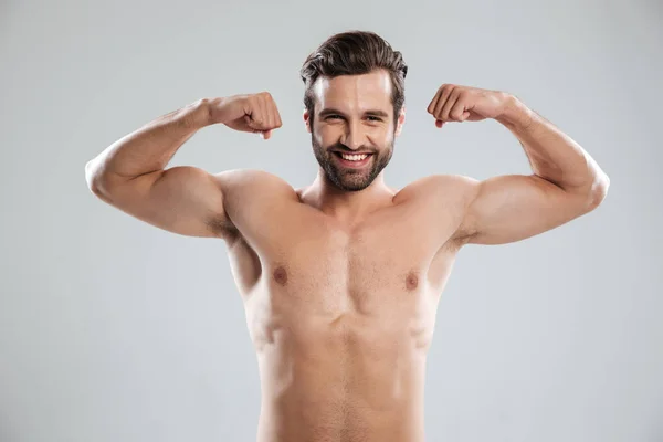 Man tonen zijn biceps en kijken naar camera — Stockfoto