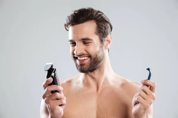 Happy young man choosing razor — Stock Photo, Image
