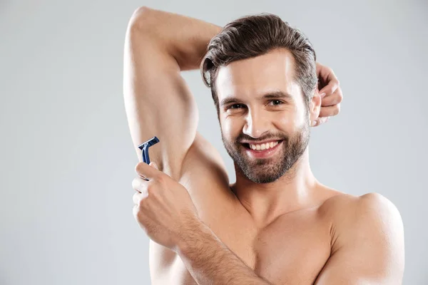 Lächelnder Mann mit Rasiermesser lächelt in die Kamera — Stockfoto