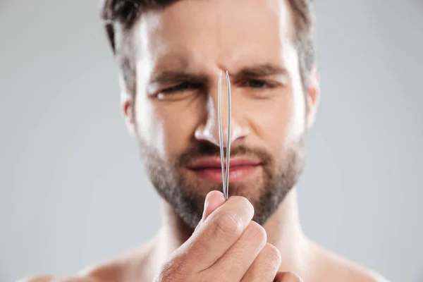 Close up tiro de homem descontente segurando tweeazer — Fotografia de Stock