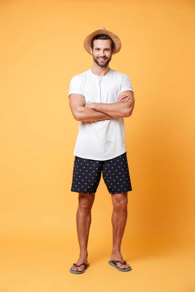 Hombre guapo con las manos dobladas posando sobre fondo naranja — Foto de Stock