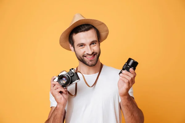 Jeune homme souriant regardant caméra tout en tenant l'objectif — Photo