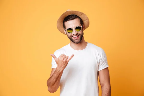 Usmívající se muž v klobouku v létě při pohledu kamery, samostatný, ukázal — Stock fotografie