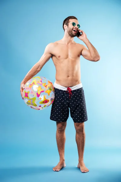 Po celé délce portrét mladý chlap drží míč beach — Stock fotografie