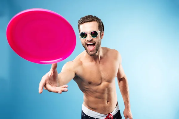 Portrait of a young excited guy in summer shorts playing — Stock Photo, Image