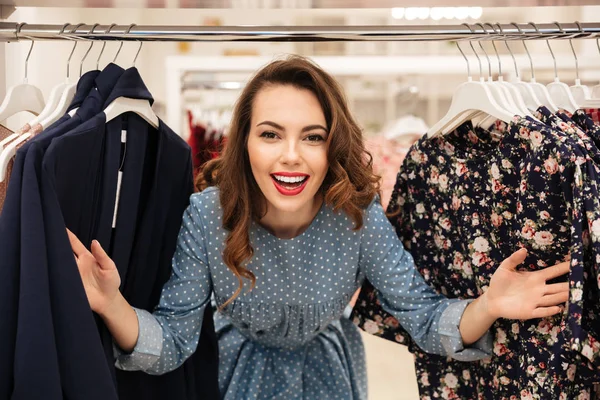 Счастливая юная леди стоит в магазине одежды — стоковое фото