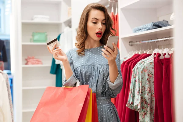 Mujer sorprendida en la tienda con smartphone — Foto de Stock