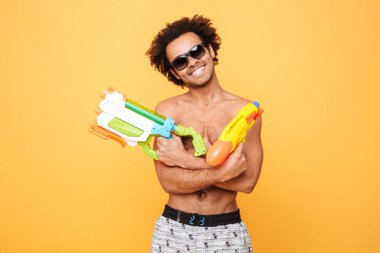 Neşeli genç Afrika adam elinde oyuncak su silah.