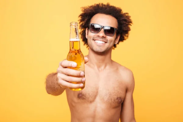 Retrato de un hombre africano en gafas de sol mostrando una botella de cerveza — Foto de Stock