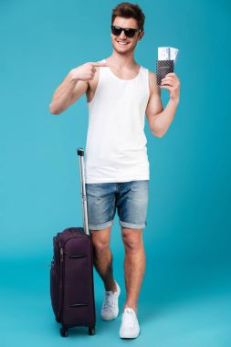 Bilet tutarak ve işaret eden yakışıklı adam.