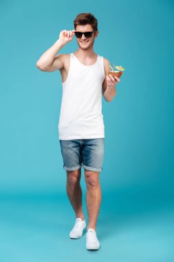 Yakışıklı adam izole mavi arka plan üzerinde ayakta.