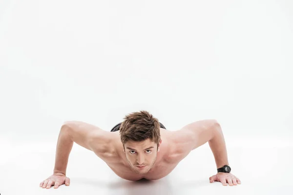 Concentrated young sportsman doing push-ups