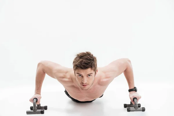 Young fit sportsman doing push ups with bars — Stock Photo, Image