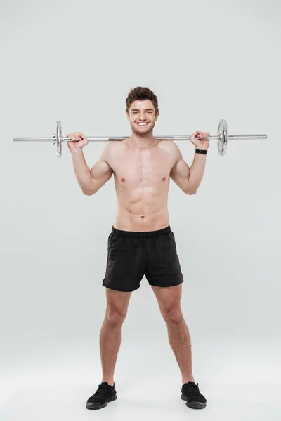 Young healthy man athlete doing exercises with barbell — Stock Photo, Image
