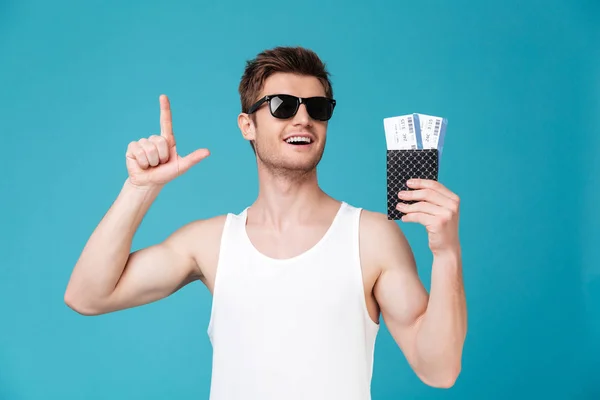 Hombre con gafas de sol sosteniendo pasaporte con entradas — Foto de Stock