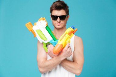 Kamera seyir ve iki su silah tutan olumlu adam