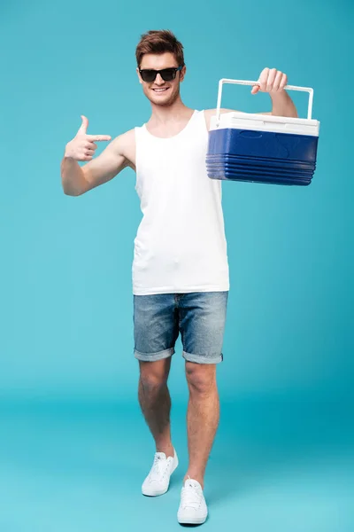 Lycklig man står över Blå isolerade bakgrund pekar — Stockfoto