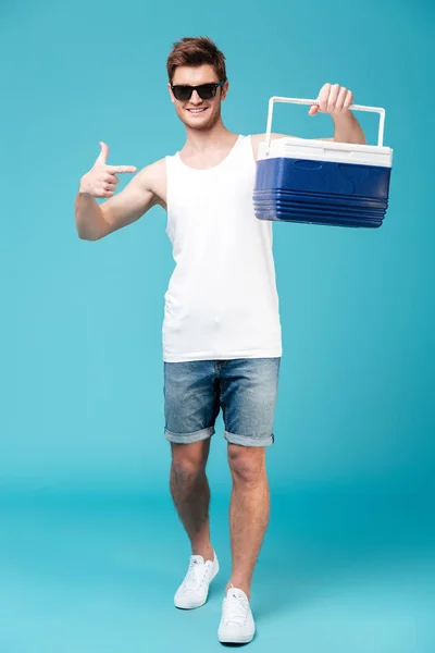 Hombre feliz de pie sobre fondo azul aislado señalando — Foto de Stock