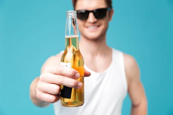 Hombre sonriente bebiendo cerveza. Enfoque en la cerveza . — Foto de Stock