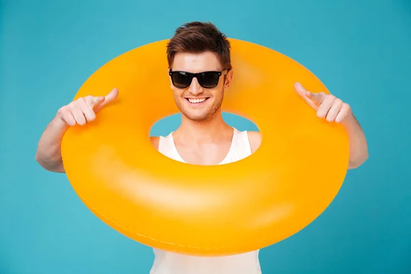 Guy en lunettes de soleil tenant anneau gonflable autour de son cou — Photo